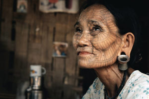 An old woman who has a face tattoo.